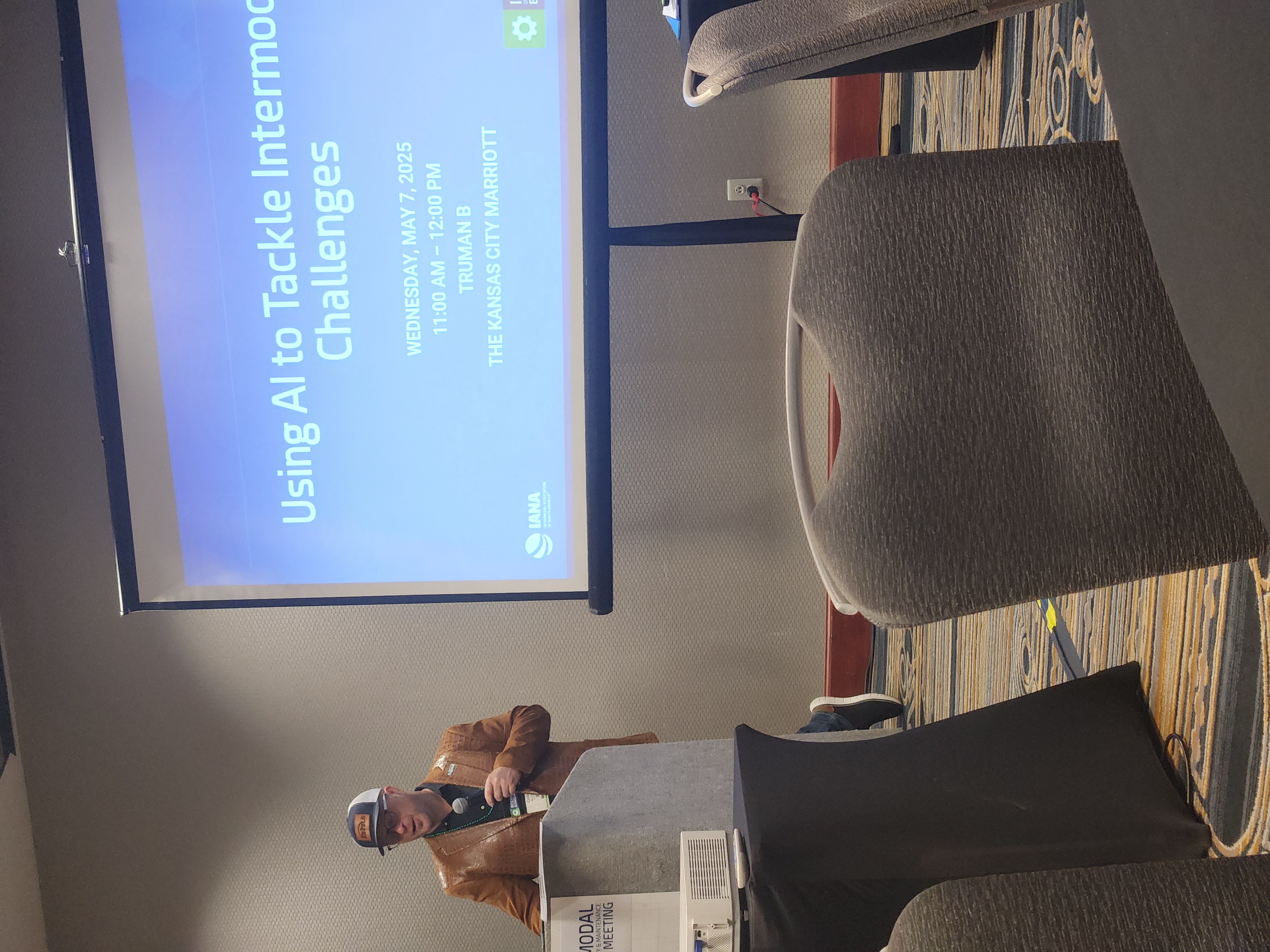 Chris Machut presenting on stage at an industry conference on AI and supply chain technology